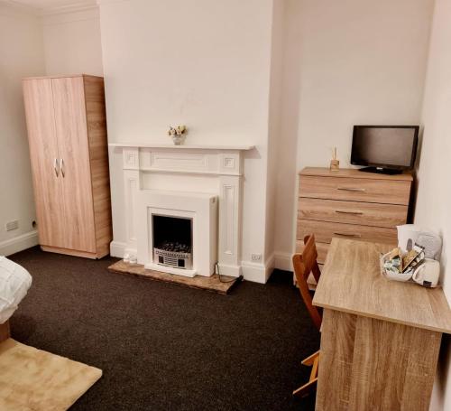 ein Wohnzimmer mit einem Kamin und einem Tisch in der Unterkunft Lilies Lodge in Balby