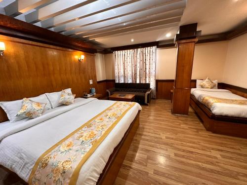 a hotel room with two beds and a couch at Hotel Gajraj in Gangtok