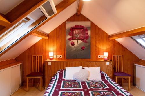 une chambre avec un lit dans un grenier dans l'établissement Maison de pays, à Belz