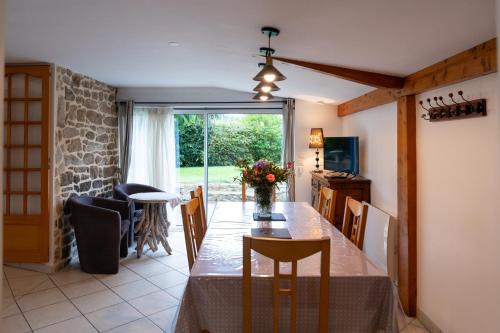 une cuisine et une salle à manger avec une table et des chaises dans l'établissement Maison de pays, à Belz