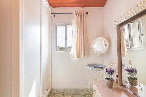uma casa de banho com um lavatório, um espelho e uma janela em Casa das Bonecas em Farelos de Baixo