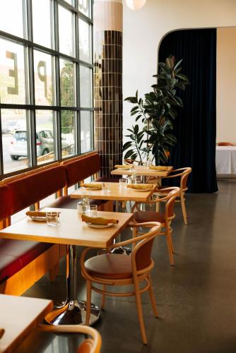 a restaurant with wooden tables and chairs and windows at Waymore's Guest House & Casual Club in Nashville