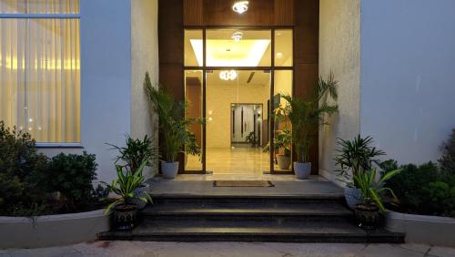 a front door of a building with potted plants at Mayur Belgaum Presidency Hotel & Spa in Belgaum