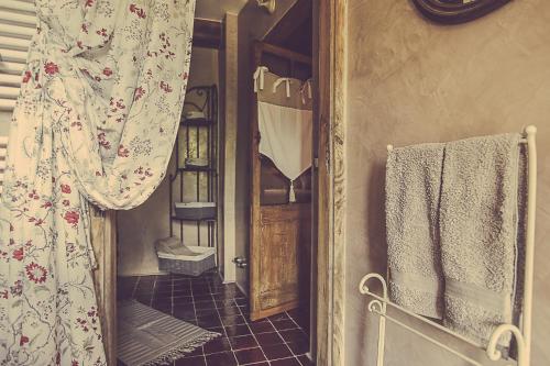 La salle de bains est pourvue d'un miroir et d'une porte avec des serviettes. dans l'établissement Relais di charme Frazione Chiavolino, à Pollone