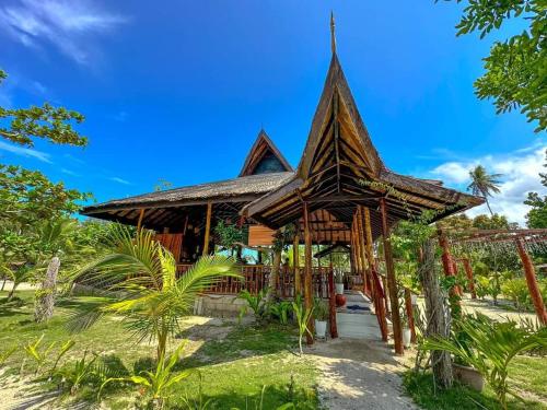a bamboo house with a pathway leading to it at La Tranquilidad Beach Club 