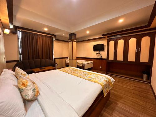 a hotel room with a large bed and a chair at Hotel Gajraj in Gangtok