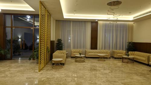 a lobby with couches and tables in a building at Mayur Belgaum Presidency Hotel & Spa in Belgaum