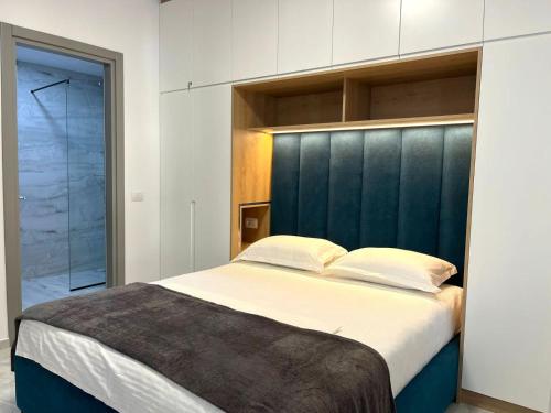a bedroom with a large bed with a blue headboard at Diamond DREAM in Sarandë