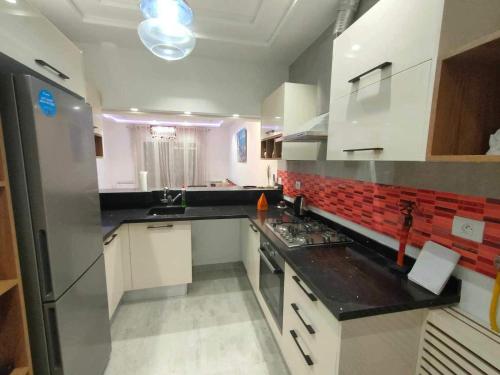 a kitchen with white cabinets and a black counter top at Dar Al Yaqout in Le Kram