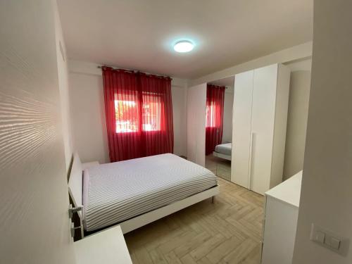 1 dormitorio pequeño con 1 cama y cortinas rojas en Amethyst Apartment, en Artena