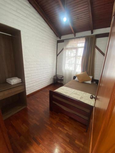 a bedroom with a bed in a room with a window at Apartment - Quinta Las Buganvillas in Ambato