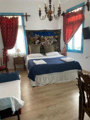 a bedroom with a bed with blue sheets and red curtains at DIONI 2 in Chania