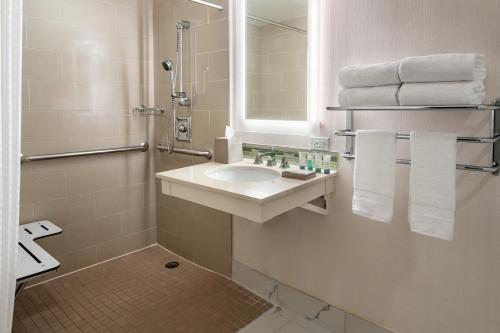 a bathroom with a sink and a mirror and towels at The Westin Atlanta Airport in Atlanta