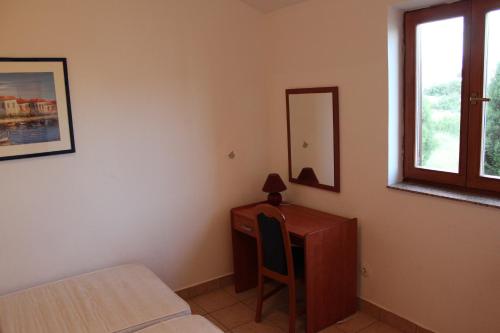 una camera da letto con scrivania, letto e specchio di Apartments Marszalek a Novalja (Novaglia)