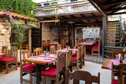 a restaurant with wooden tables and chairs in a building at Heritage Hotel Tragos in Trogir