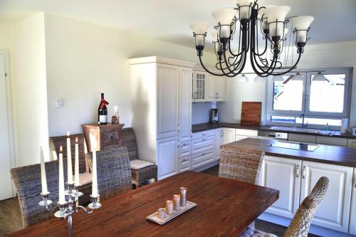 a kitchen with a wooden table and a chandelier at quiet and central Luxury Villa "JUWEL" with Sauna, at Ski slope! in Sankt Michael im Lungau