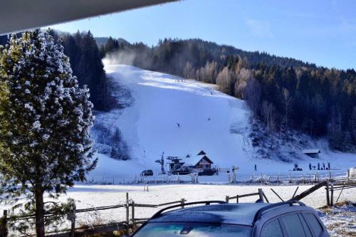 a car parked in front of a snow covered ski slope at quiet and central Luxury Villa "JUWEL" with Sauna, at Ski slope! in Sankt Michael im Lungau