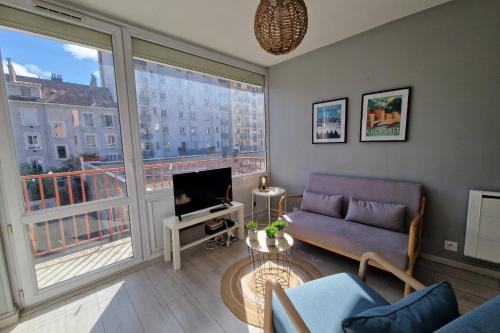 - un salon avec un canapé et une grande fenêtre dans l'établissement View on the Bastille Center Terrace All equipped #E0, à Grenoble
