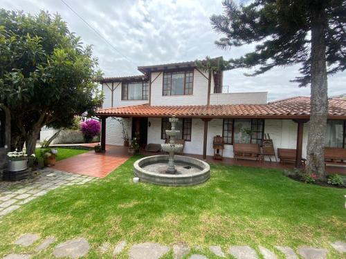 a house with a fountain in the yard at Apartment - Quinta Las Buganvillas in Ambato