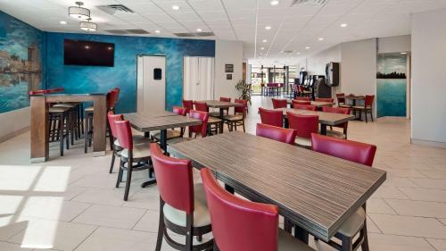 un restaurante con mesas de madera y sillas rojas en Best Western Plus Wausau Tower Inn, en Wausau