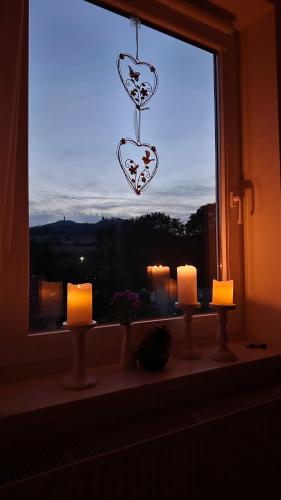 a window with candles and a heart hanging from it at Ferienwohnungen Hexenstieg & Wurmbergblick in Schierke