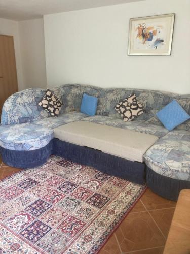 a couch in a living room with blue pillows at Immensee in Ronshausen