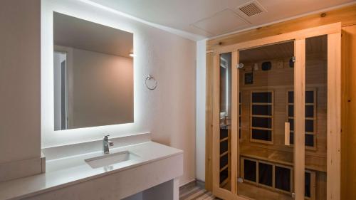 a bathroom with a sink and a mirror and a shower at Best Western Plus Wausau Tower Inn in Wausau