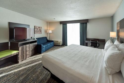 a hotel room with a bed and a couch and a television at Best Western Plus Wausau Tower Inn in Wausau