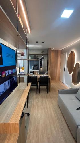 uma sala de estar com um sofá e uma mesa com uma televisão em Studio Cosmopolita - Novo - possui automação em Nova Santa Medianeira