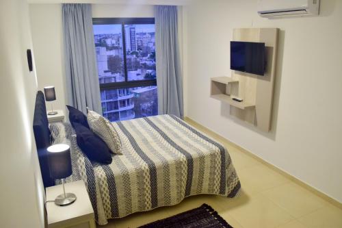 a bedroom with a bed and a window with a view at Agustín I Apart in Paraná