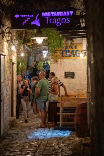 a group of people walking down a street at night at Heritage Hotel Tragos in Trogir