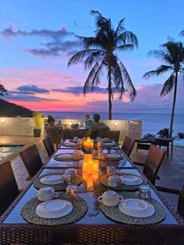 a table set for a meal with a view of the ocean at AV Suites in Puerto Galera