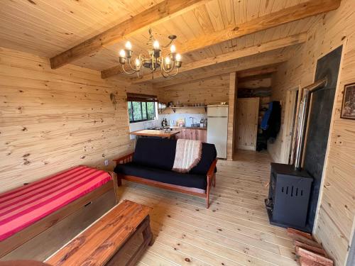 Una habitación con un banco y una estufa en una cabaña en Cabaña Los Ceibos., en Villa Serrana