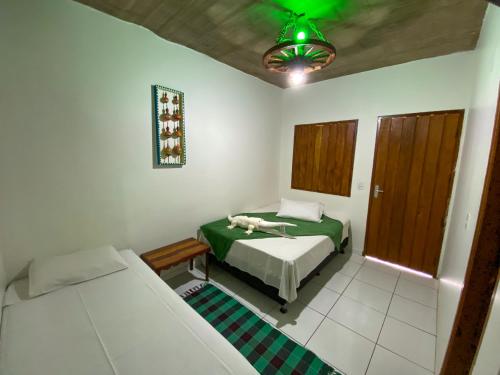 a bedroom with two beds and a green ceiling at Pousada Segredo in Bonito