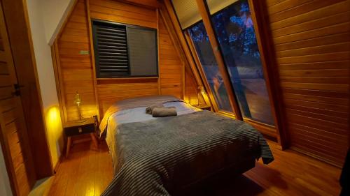 a bedroom with a bed in a room with a window at CABANA HAIGAZ de MONTANHA in Marmelopolis