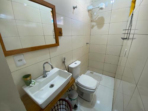 a bathroom with a toilet and a sink and a shower at Pousada Segredo in Bonito