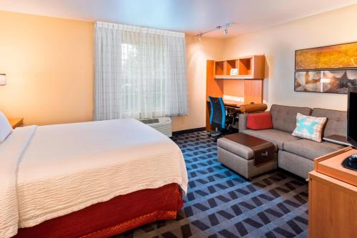 une chambre d'hôtel avec un lit et un canapé dans l'établissement TownePlace Suites by Marriott Atlanta Kennesaw, à Kennesaw