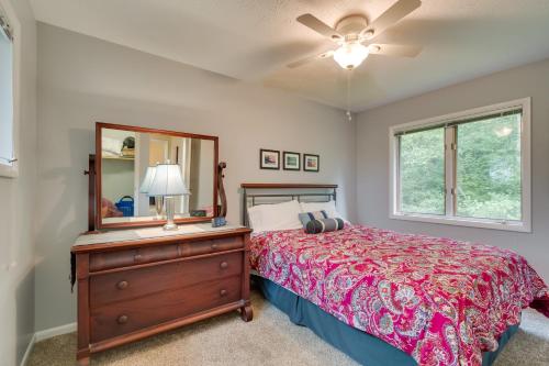 a bedroom with a bed and a dresser and a mirror at WolcottandPort Bay Lakehouse Your Haven on the Bay! in Wolcott