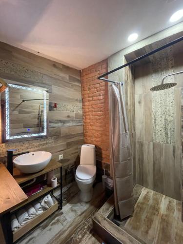 Un baño con inodoro, lavabo y ducha. en kushki's home, en Tiflis