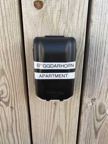 a black soap dispenser on a wooden fence at Byggðarhorn in Selfoss