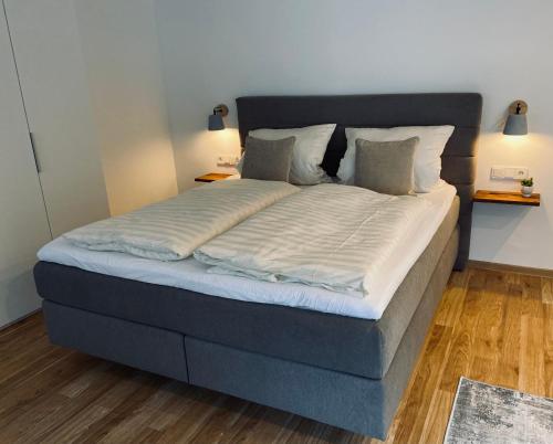 a large bed with white sheets and pillows at HALBSTÜCK - Ferienwohnungen am Kropsbachpark in Sankt Martin