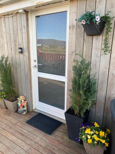a door to a deck with potted plants and flowers at Byggðarhorn in Selfoss