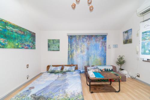 a room with a bed and a couch and paintings at Claude Monet Tokyo Shibuya Shinjyuku Wifi Free! in Tokyo
