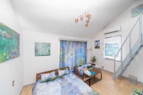 a living room with a bed and a staircase at Claude Monet Tokyo Shibuya Shinjyuku Wifi Free! in Tokyo