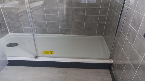 a shower with a white tub in a bathroom at Le chalet de CLEM & SAND in Saint-Riquier-ès-Plains