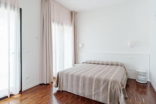 a bedroom with a bed with a striped blanket at Residenze Di La' Dal Fiume in Caorle