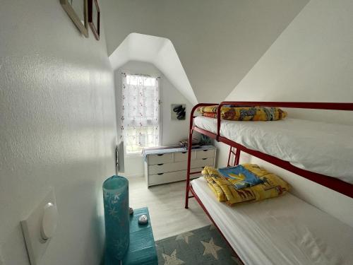 een slaapkamer met 2 stapelbedden en een raam bij Maisonnette de bord de mer in Guidel