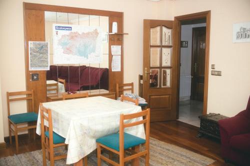 ein Esszimmer mit einem Tisch, Stühlen und einer Tür in der Unterkunft Las Caldas de Boñar Casa alquiler completo in Boñar