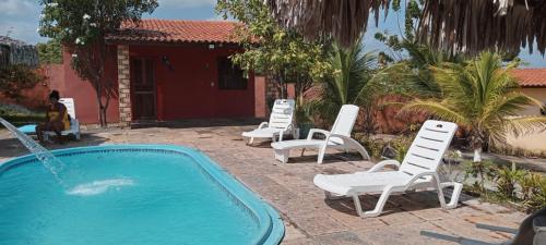 a group of lawn chairs and a swimming pool at pousada chykos in Barreirinhas