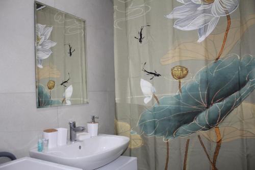 a bathroom with a sink and a shower curtain at ЖК Терра in Almaty